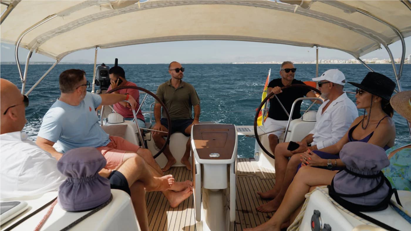 Guests seated in the shaded cockpit of the Candela private sailing yacht